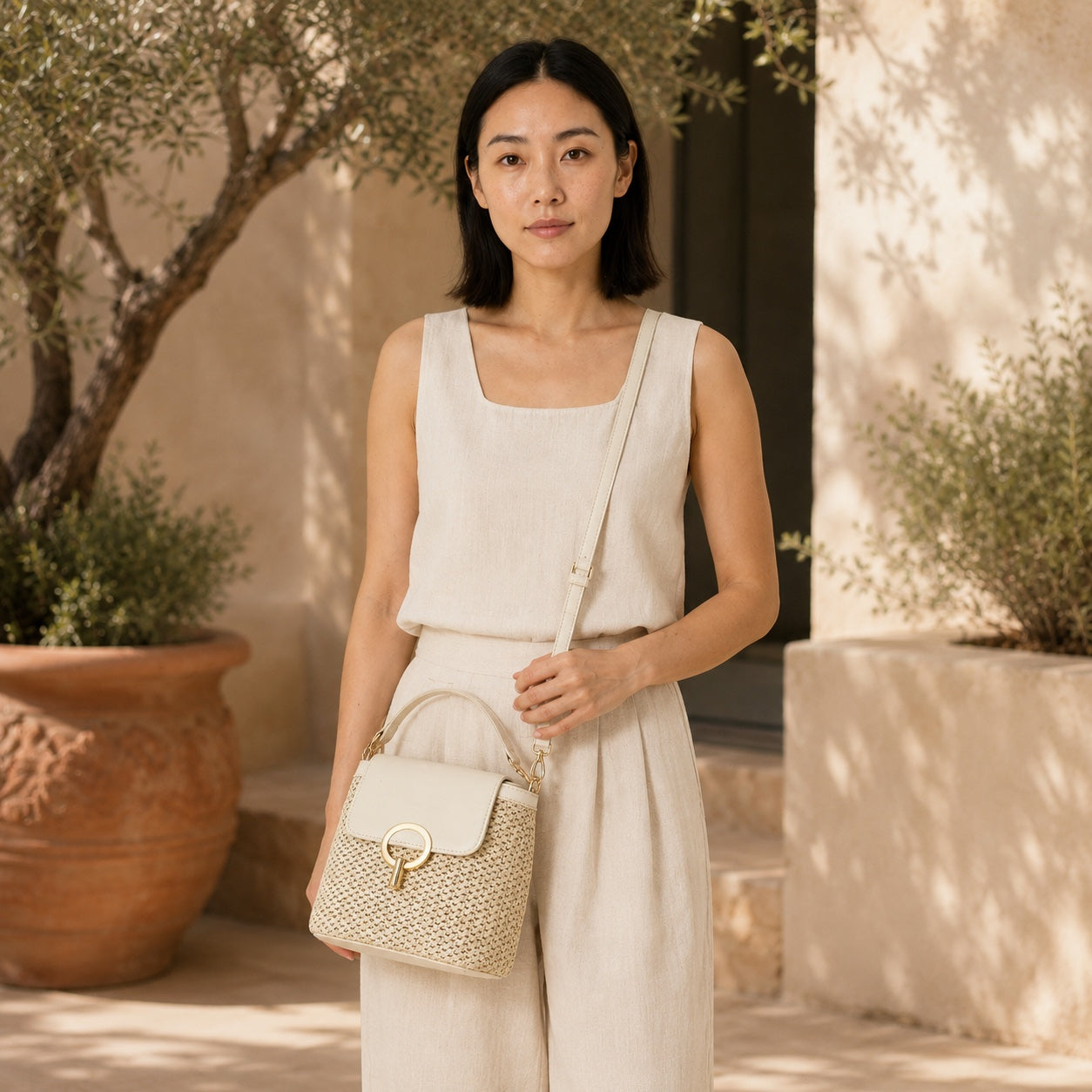 Model carrying the Sveti - Straw Crossbody Bag